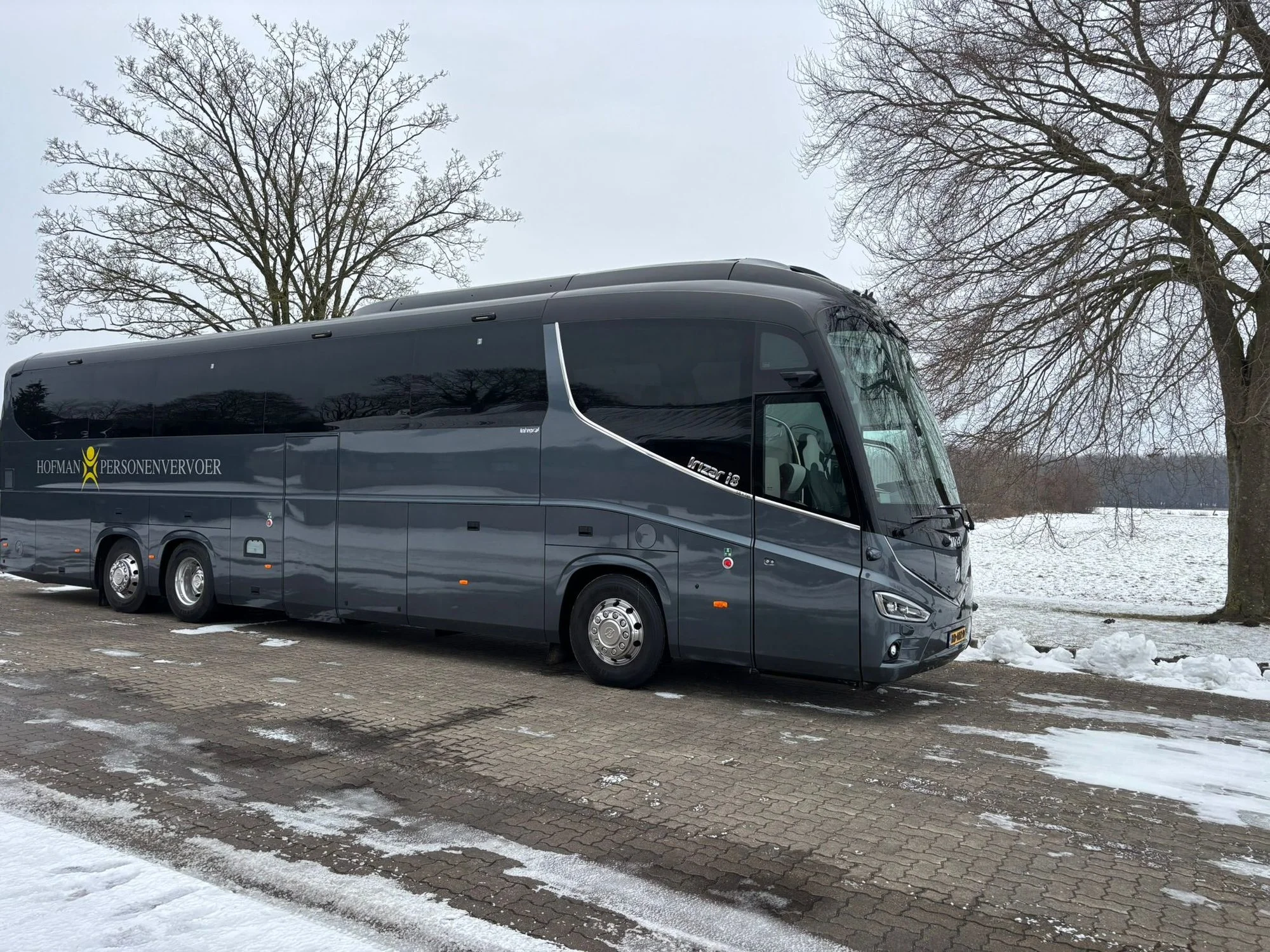 Touringcar van Hofman Personenvervoer in een winters landschap